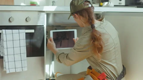 Plumber Inspecting Pipes with Tablet Stock Footage 310747844