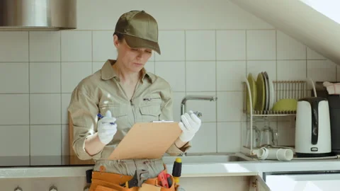 Plumber Inspecting Plumbing Part in Kitchen Stock Footage 309489915