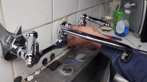 Plumber installing new faucet in kitchen sink Stock Footage 249923945