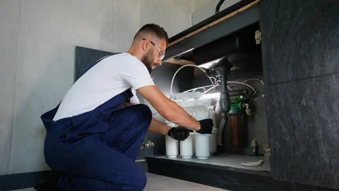Plumber Installing Reverse Osmosis Filtration System Under Sink Stock Footage 289779556