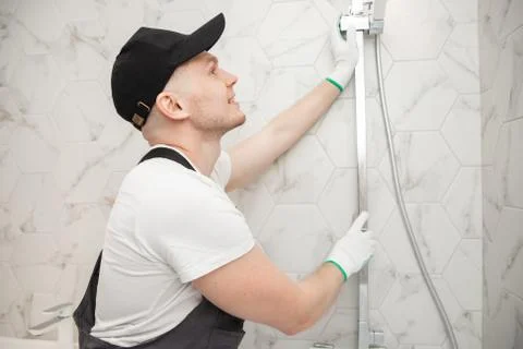 Plumber installing shower stall, work in bathroom Stock Photos