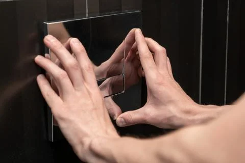 Plumber installs a flush button Stock Photos