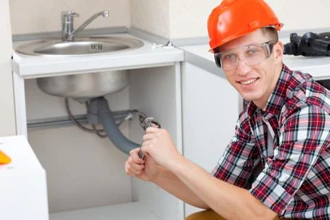 Plumber at the kitchen Stock Photos