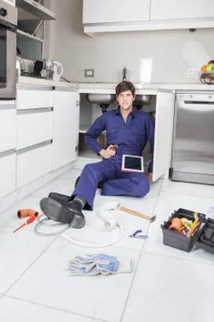Plumber looking at the instructions in your tablet Stock Photos
