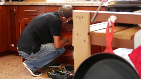 Plumber man with tools in the kitchen. Plumbing and renovation Stock Footage 71837407