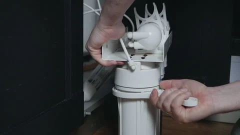 Plumber or Man hand replace cartridges for water filter in home kitchen. Fixed Stock Footage 128766923