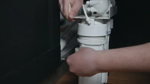 Plumber or Man hand replace cartridges for water filter in home kitchen. Fixed Stock-Footage 128767016