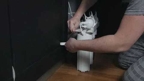 Plumber or Man hand replace cartridges for water filter in home kitchen. Fixed Stock Footage 129188854
