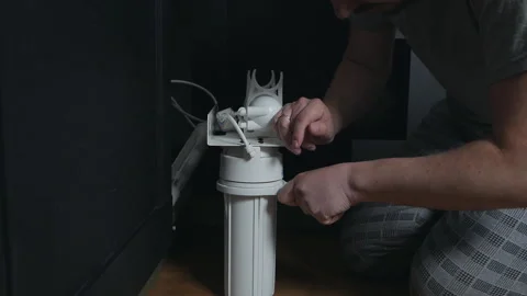 Plumber or Man hand replace cartridges for water filter in home kitchen. Fixed Stock Footage 129536756