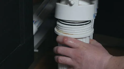 Plumber or Man hand replace cartridges for water filter in home kitchen. Fixed Stock Footage 129703517