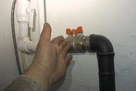 The plumber points with his hand at an element of the heating pi Stock Photos