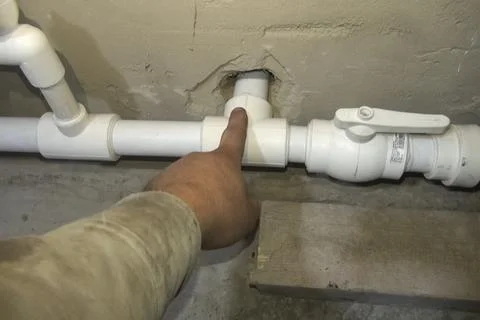 The plumber points with his hand at an element of the heating pi Stock Photos