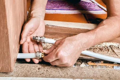 Plumber positions compression ring onto multilayer pipe as part of fitting .. Stock Photos