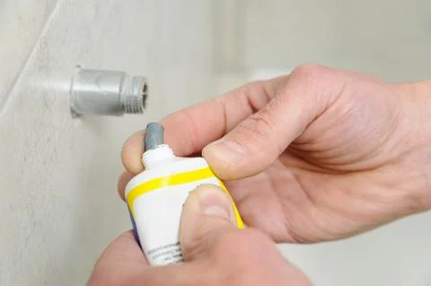 Plumber putting a paste sealant. Stock Photos