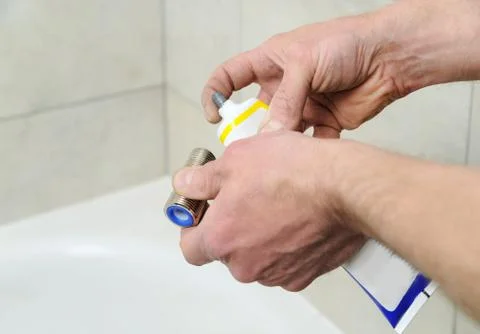 Plumber putting a paste sealant. Stock Photos