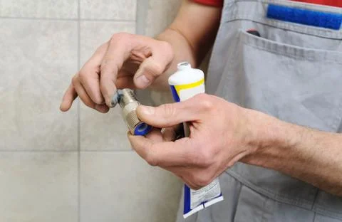 Plumber putting a paste sealant. Stock Photos