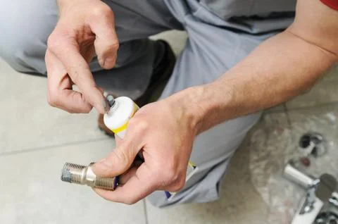 Plumber putting a paste sealant. Stock Photos