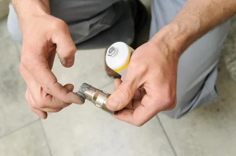 Plumber putting a paste sealant. Stock Photos