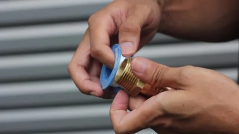 Plumber putting seal tape on a thread of a plumbing fitting Stock Footage 290884493