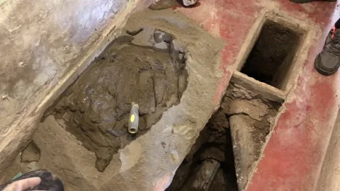 Plumber removing concrete from broken pipe during renovation Stock Footage 337672838
