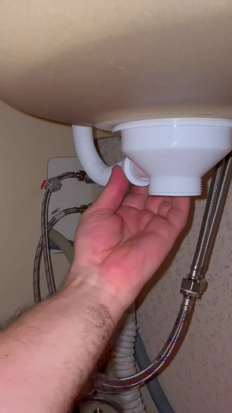 Plumber repairing kitchen sink drain pipes. Man installing white plastic siphon Stock Footage 340124672