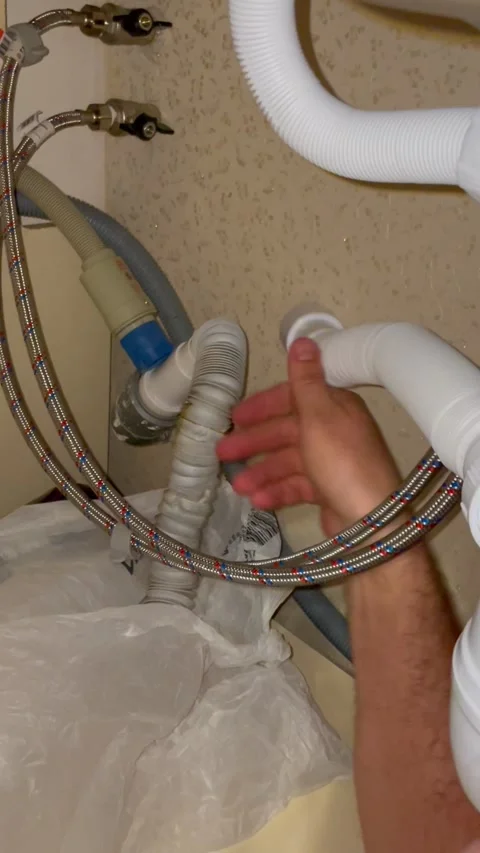 Plumber repairing kitchen sink drain pipes. Man installing flexible white Stock Footage 340124713