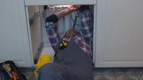 Plumber repairs a siphon leak in a kitchen sink Stock Footage 131215695