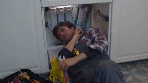 Plumber repairs a siphon leak in a kitchen sink Stock Footage 131260533