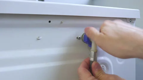 Plumber serviceman connect and install cold water supply flexible hose to Stock Footage 158219472
