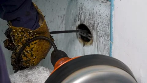 A plumber snaking the bathtub drain  Video stock 318577186