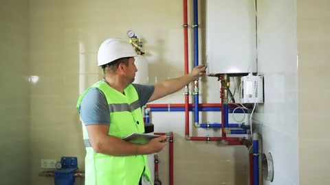 Plumber starts up heating system in house. Boiler maintenance service. Setting Stock Footage 322731094