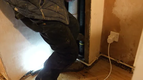 Plumber is struggling to pull out inflatable packer from vertical soil vent pipe Видео 303210900