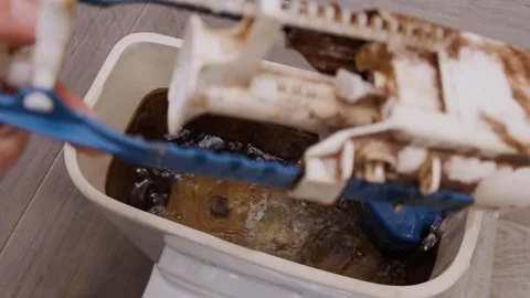 A plumber takes out an old cistern fittings from a dirty rusty toilet tank Stock Footage 244655995