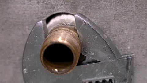 Plumber tightening brass pipe fitting with adjustable wrench 스톡 동영상 304118551