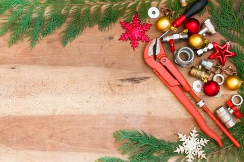 Plumber  tools, fittings and Christmas decorations on wooden background Stock Photos