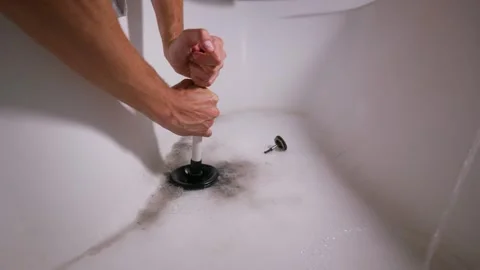 Plumber Unclogging Bathtub Drain with Rubber Plunger in Home Bathroom Stock Footage 345427062