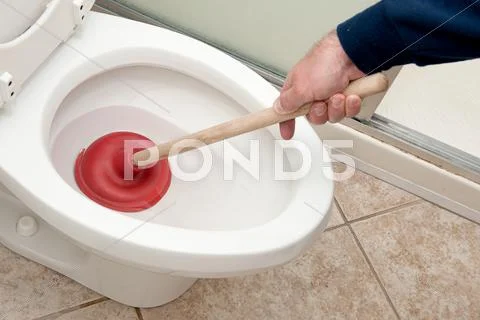 Plumber uncloging toilet Stock Photos