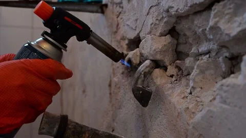 Plumber using a gas torch to heat old bathroom pipes Stock Footage 346958785