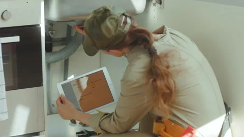 Plumber Using Tablet for Kitchen Sink Repair Stock Footage 316080342