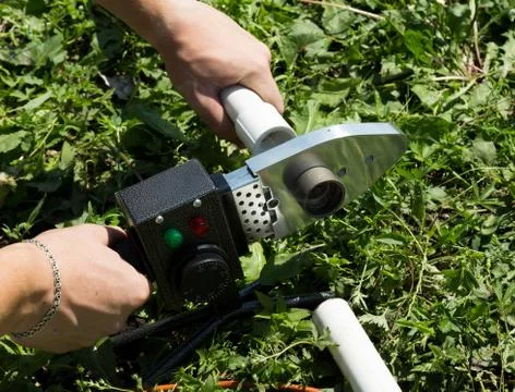 Plumber with welding machine connecting plastic pipes Stock Photos