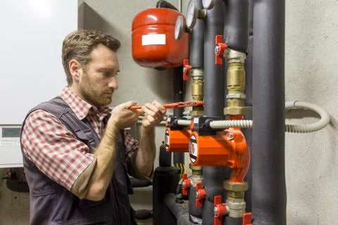 Plumber at work installing a circulation pump 库存照片