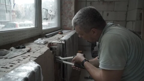 Plumber at work. Installing water heating radiator Stock Footage 101551248