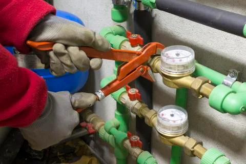 Plumber at work installing a water meter Stock Photos