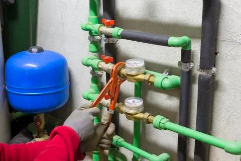 Plumber at work installing a water meter Stock Photos