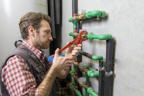 Plumber at work installing a water meter Foto stock