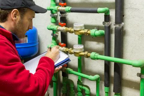 Plumber at work making the consumption metering Stock Photos