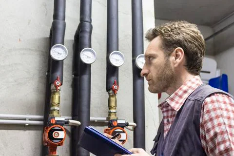 Plumber at work making the consumption metering Stock Photos