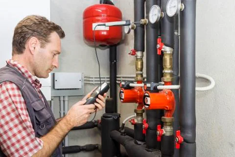 Plumber at  work measures the temperature in a boiler room Stock Photos