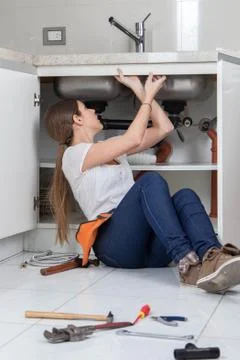 Plumber working in the kitchen Stock Photos