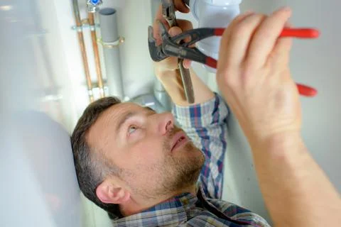 Plumber working on a pipe Stock Photos